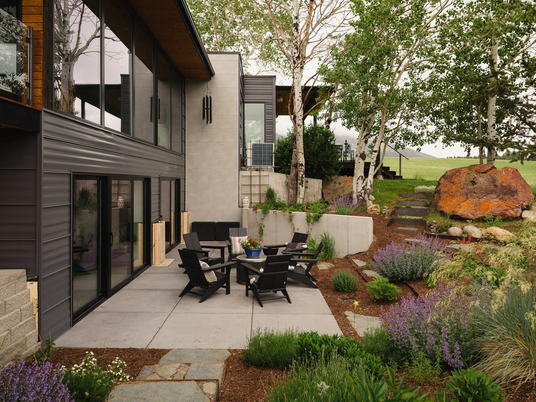 Exterior courtyard patio with Adirondack chairs and boulder landscaping — architectural photography Bozeman Montana, Bozeman Overlook